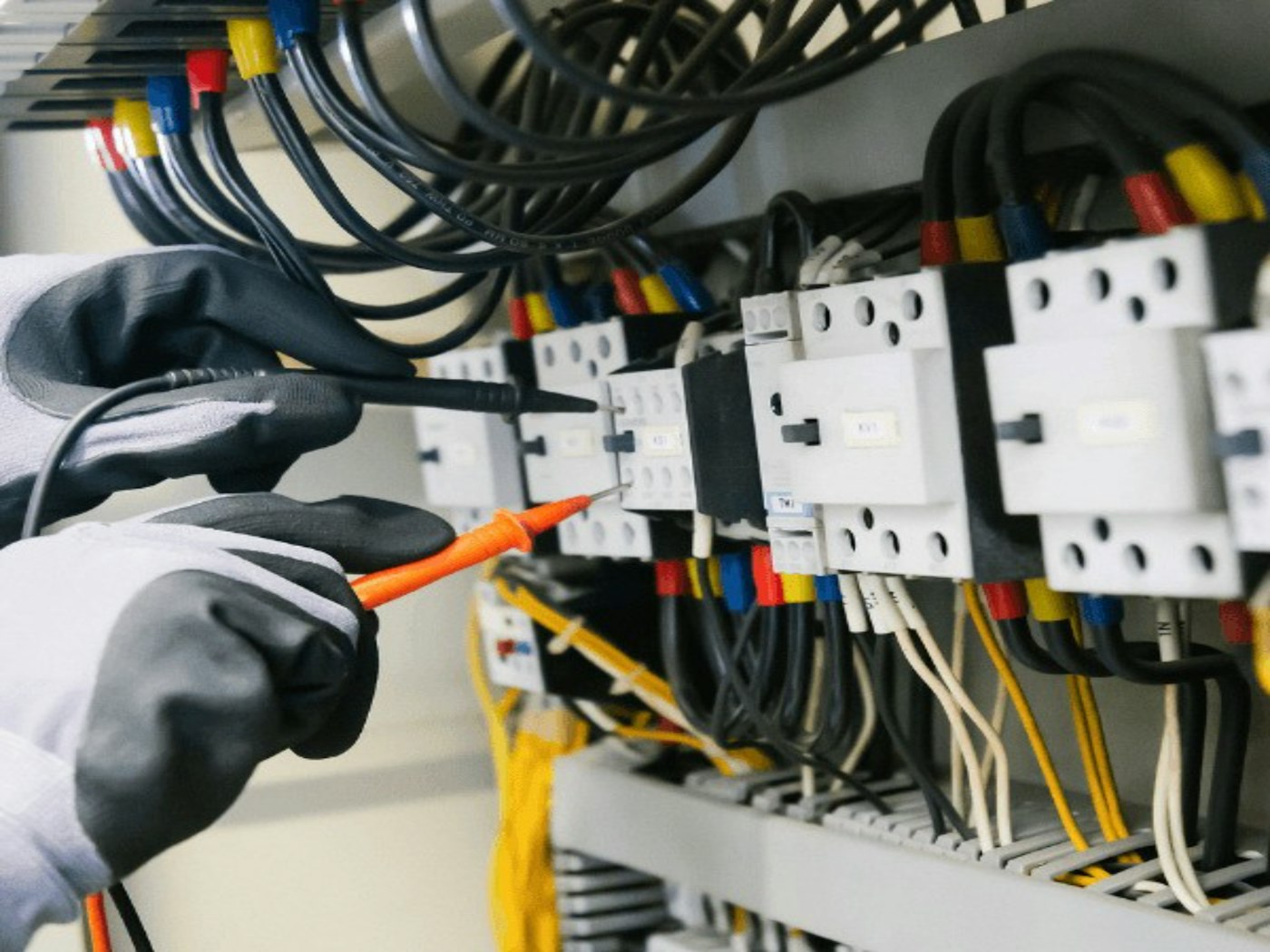 Électricien contrôlant un tableau électrique au multimètre